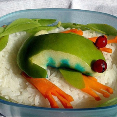 A creative kids plate with fruit and veggies arranged to look like a frog
